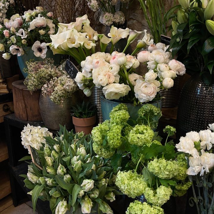 An elegant display of various fresh flowers in a rustic indoor setting.